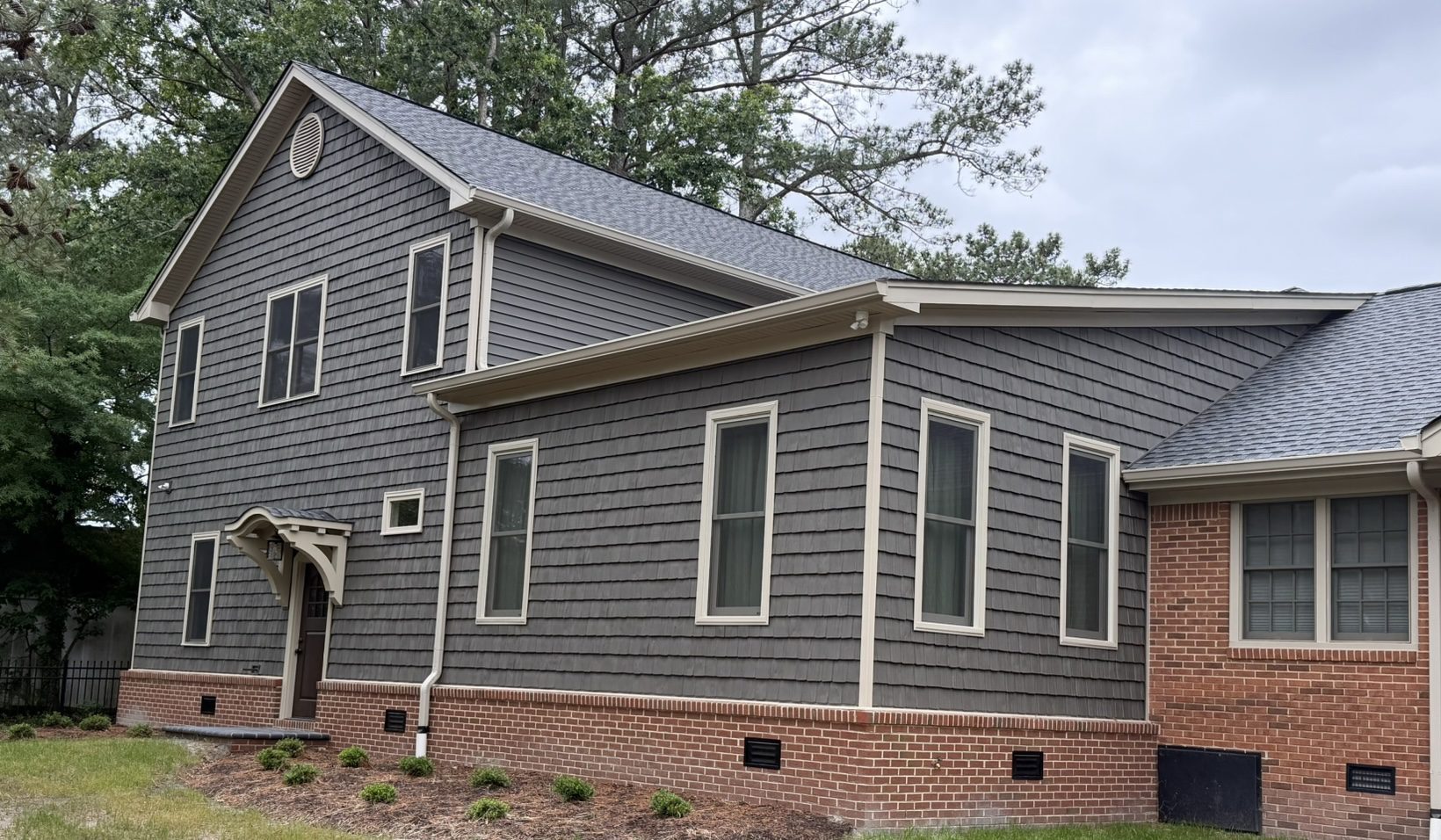 Gray two-story house with brick foundation