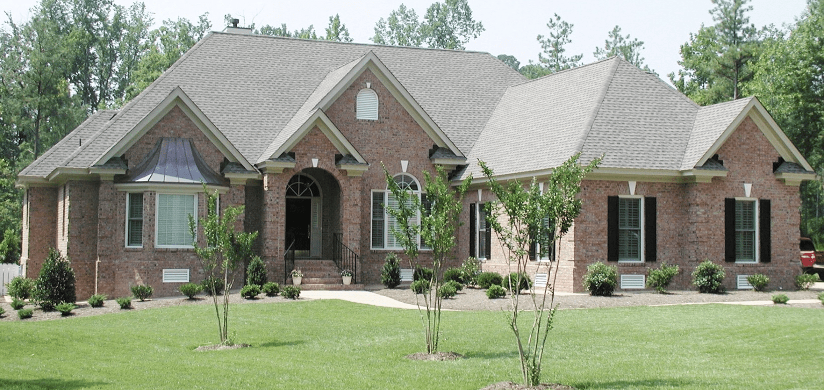 Large brick suburban house with manicured lawn