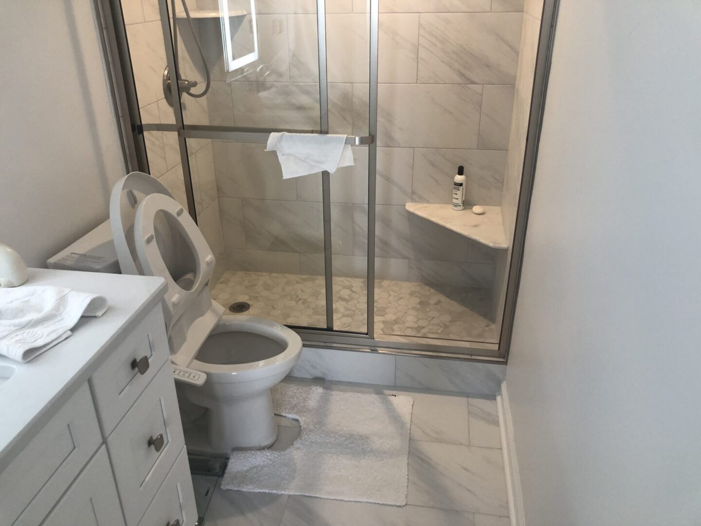 Small modern bathroom with glass shower and toilet